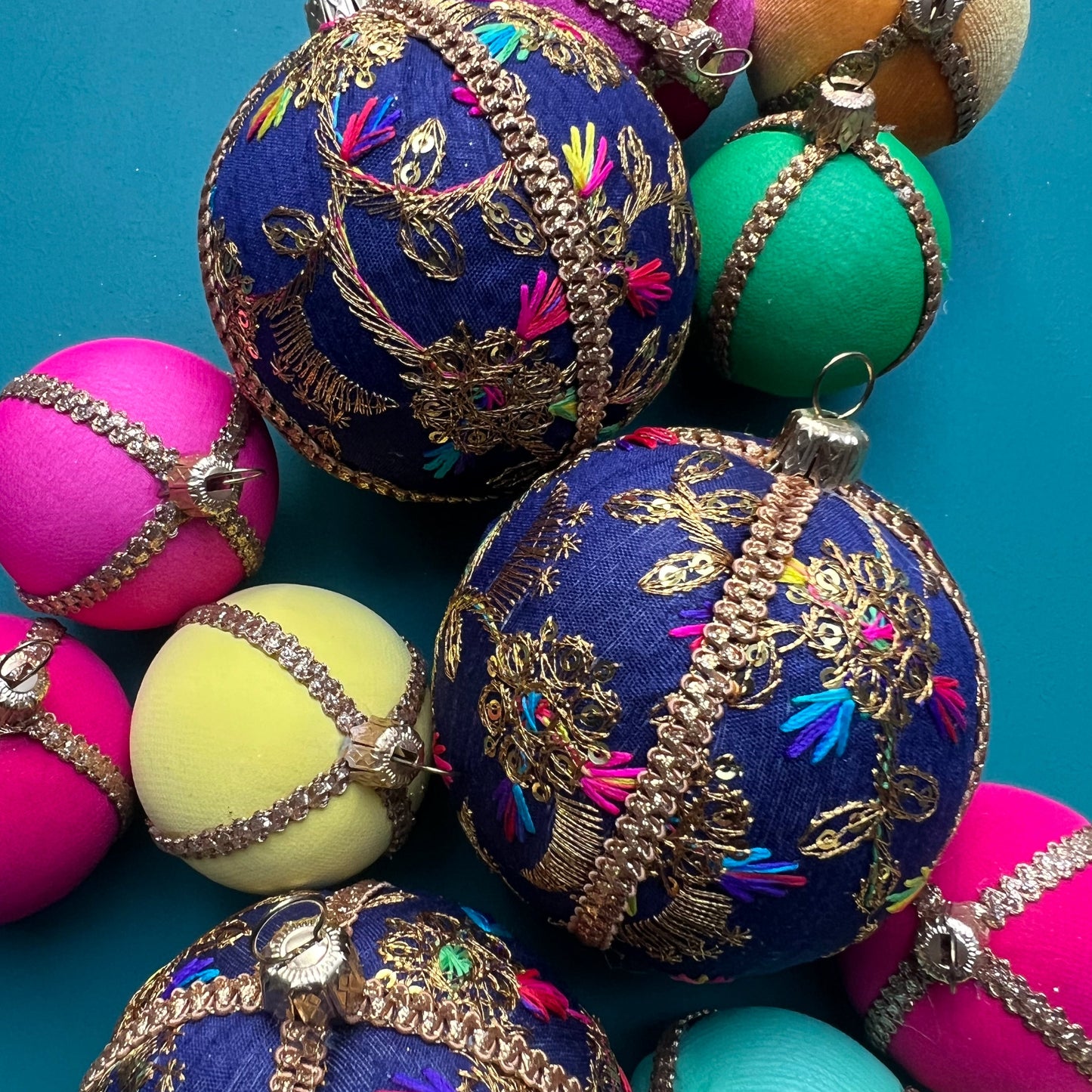Close-up of Aasha deep blue handmade embroidered baubles with intricate golden threadwork, eco-friendly luxury decorations for festive home styling and Christmas tree ornaments