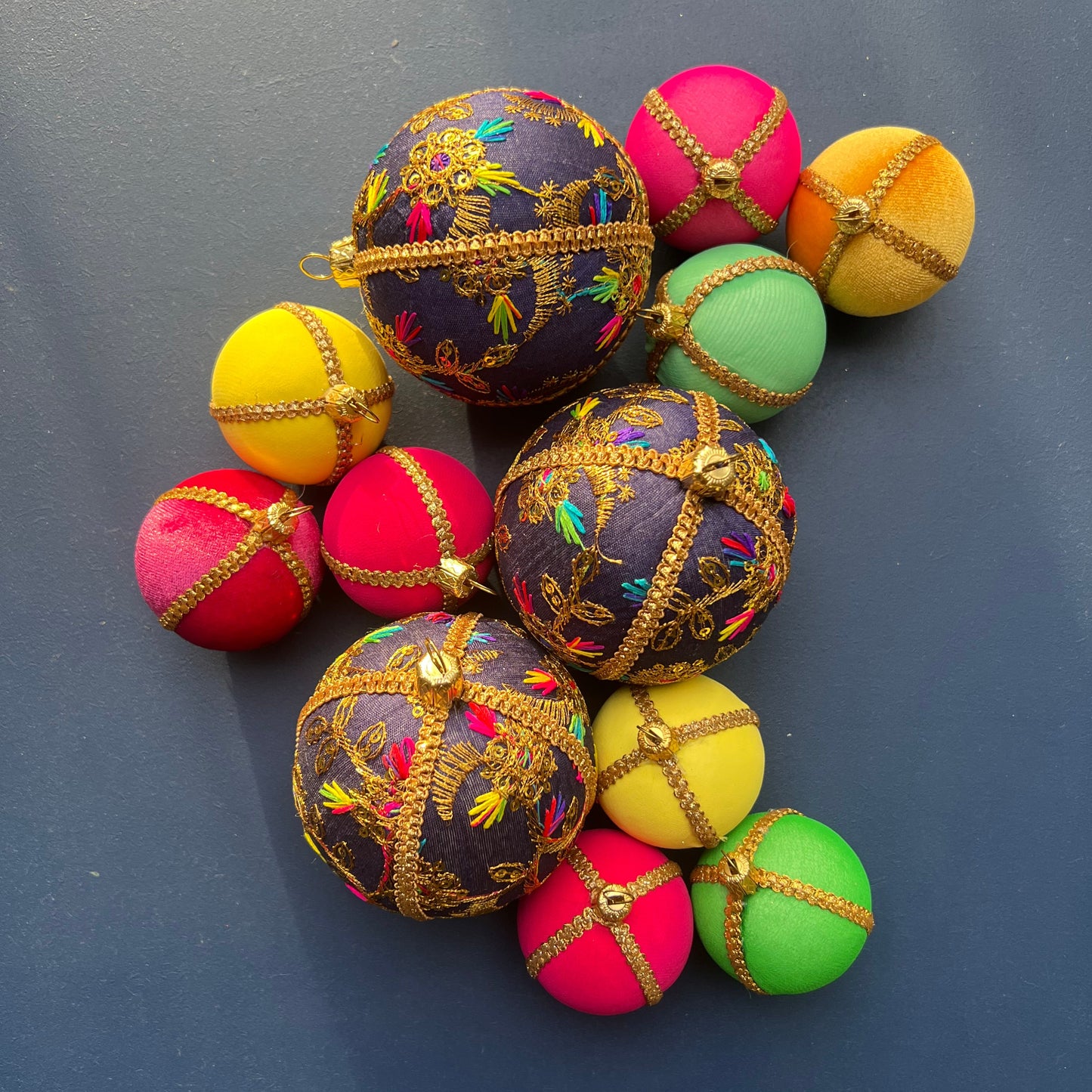 Handmade Aasha deep blue embroidered baubles with gold floral stitching, vibrant eco-friendly Christmas decorations in bold colourful designs, sustainable festive ornaments.