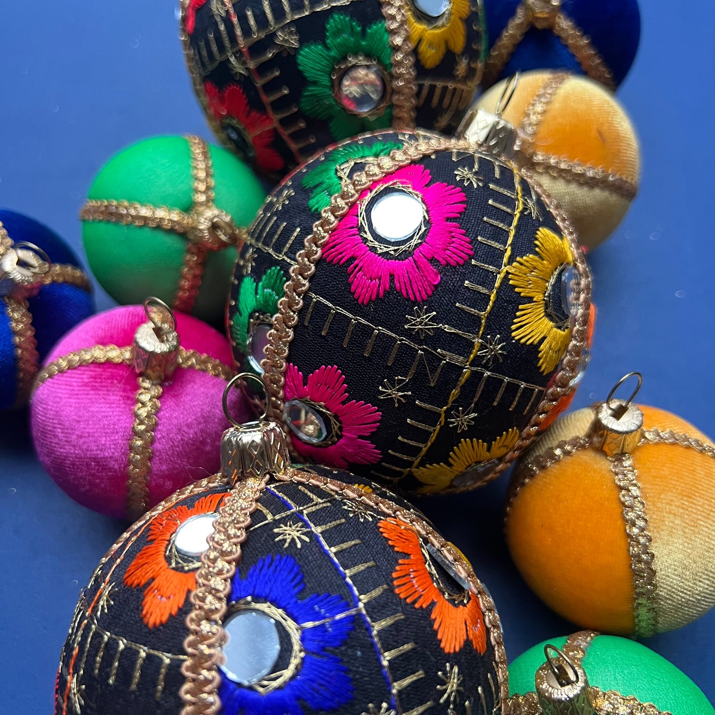 Close-up of Vimal vibrant black floral handmade baubles, eco-friendly Christmas decorations in bold multicolour designs