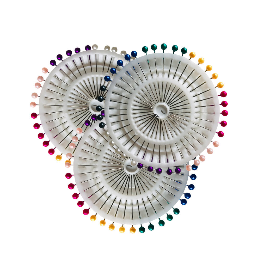 Flat lay of rainbow and white pearl dressmaking pin wheels — compact, colourful, and perfect for sewing, crafting and Mashquin styling.