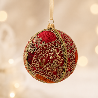 Aarna bauble detail shot, a 10cm UK-made sustainable ornament with hot pink ground and sweeping gold zari cord goldwork in paisley and floral forms with dense gold sequins.