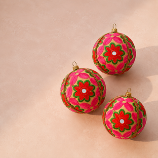 Close-up of the Advik bauble showing large-scale hand-embroidered daisy and sunflower motifs with shisha mirror centres on warm cream reclaimed fabric.