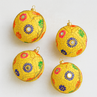 Four yellow decorative ornaments with colorful patterns on a white background.Luxury handmade bauble in yellow with intricate gold embroidery, jewel florals, and mirrorwork, sustainable ornament for Christmas, weddings, and heirloom gifting.