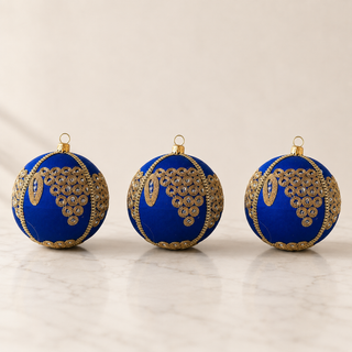 A cluster of Arjun handmade fabric baubles, 10cm, grouped to show the cascading gold mirror-work medallions with an elongated leaf motif.
