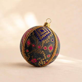 Chirag handmade fabric bauble, 8cm, charcoal ground with a dense gold checkerboard pattern lifted by magenta and cobalt blue accents.