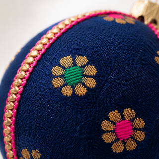 A cluster of Dancing Florals handmade fabric baubles, 8cm, grouped to show the scattered gold flower motifs with jewel-tone pink, green and blue centres.
