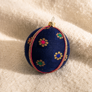 Close-up of the Dancing Florals bauble showing scattered gold flower motifs with jewel-tone pink, green and blue centres on deep navy reclaimed fabric.