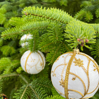 A cluster of Shashi handmade fabric baubles, 10cm, grouped to show the raised gold zardozi embroidery in a sweeping vine and trellis pattern with beaded flowers.