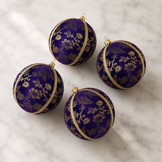 A cluster of Kaasni handmade fabric baubles, 8cm, grouped to show the sweeping gold floral scrollwork brocade with a fine cord seam trim.