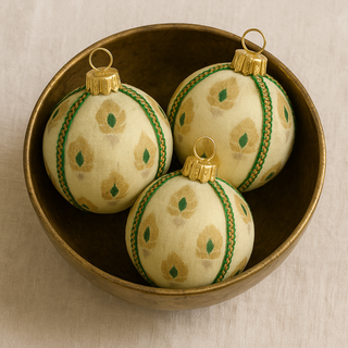 Close-up of Kamla Bauble showing gold and green embroidered motifs on cream base.