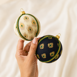 A cluster of Kamla handmade fabric baubles, 8cm, grouped to show the delicate gold floral motif with green accents and a green-and-gold cord trim.
