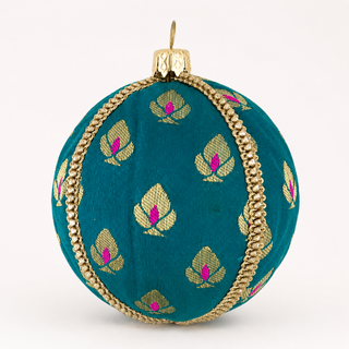 A round teal green fabric ornament decorated with gold metallic leaf motifs and pink centers, accented by a twisted gold cord border and a gold hanging cap.