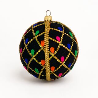 A round black Christmas ornament decorated with a gold chain lattice pattern, a central gold vertical stripe, and small colorful embroidered dots in pink, blue, green, orange, and purple, shown on a white background.