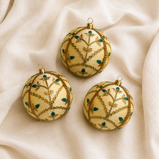 Close-up of the Lalit bauble showing delicate gold floral embroidery with teal thread accents and a metallic gold trim on ivory and gold reclaimed fabric.