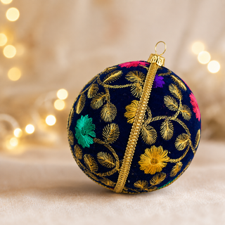 Close-up of the Mahir bauble showing fine gold fern-leaf embroidery with scattered pink, purple and teal florals on deep navy reclaimed fabric.