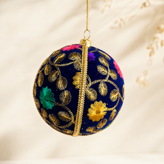 Mahir fabric bauble held in hand, highlighting the scale and sustainable, reclaimed-textile craftsmanship of this 10cm bauble.