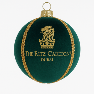 Green ornament with gold detailing and 'The Ritz-Carlton Dubai' logo on a white background
