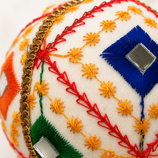 Sohan fabric bauble held in hand, highlighting the scale and sustainable, reclaimed-textile craftsmanship of this 10cm bauble.
