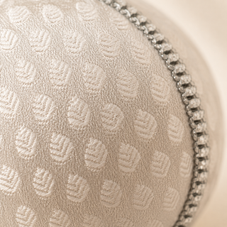 Surya fabric bauble styled on linen, an 8cm handmade ornament with a woven brocade leaf motif with a fine silver diamanté trim.
