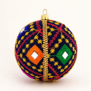 A spherical decorative ornament with a navy blue base, decorated with intricate multicolor embroidery in yellow, red, green, orange, and pink, featuring a central gold metallic zipper and a gold hanging loop at the top.