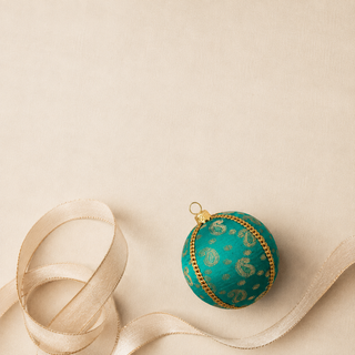 Close-up of the Tarla bauble showing gold paisley motifs and delicate dotted brocade with a gold cord seam trim on deep teal reclaimed fabric.