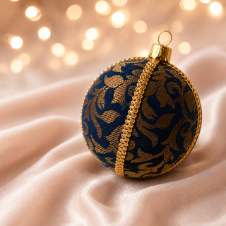 Vani fabric bauble held in hand, highlighting the scale and sustainable, reclaimed-textile craftsmanship of this 10cm bauble.