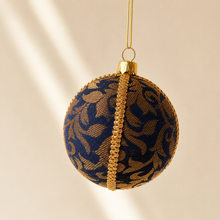 Vani handmade fabric bauble, 10cm, navy ground with sweeping gold floral scrollwork woven throughout with a gold cord seam trim.