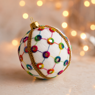 Close-up of the Vikram bauble showing a lattice of coloured thread with rainbow stitched circles and tiny mirror centres on cream reclaimed fabric.