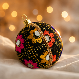 Vimal fabric bauble held in hand, highlighting the scale and sustainable, reclaimed-textile craftsmanship of this 8cm bauble.