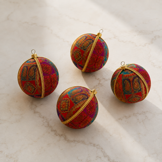 Yashodah fabric bauble held in hand, highlighting the scale and sustainable, reclaimed-textile craftsmanship of this 10cm bauble.