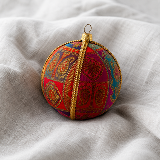 Close-up of the Yashodah bauble showing intricate gold paisley and medallion embroidery with a gold cord seam trim on magenta, teal, purple and red patchwork panels reclaimed fabric.