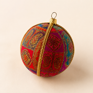 Yashodah handmade fabric bauble, 10cm, magenta, teal, purple and red patchwork panels ground with intricate gold paisley and medallion embroidery with a gold cord seam trim.
