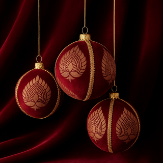 Three luxurious Anant Baubles in deep red velvet with gold embroidery, hanging against a rich velvet backdrop for a high-end festive look.