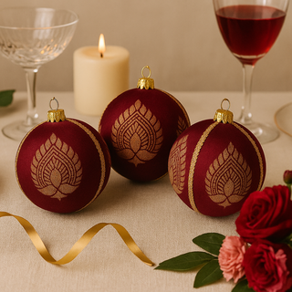 Burgundy and gold Anant Baubles styled on a luxe tablescape with ribbon, candlelight and floral details — perfect for festive or event decor.