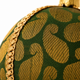 Charu fabric bauble held in hand, highlighting the scale and sustainable, reclaimed-textile craftsmanship of this 8cm bauble.