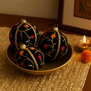 Three Kashvi Baubles in 10cm nestled in a brass bowl on a wooden surface, styled with a candle, throw, and terracotta vase to create a soft, romantic interior look.