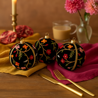 Three Kashvi Baubles in 10cm styled on a wooden table with mustard and magenta fabrics, gold cutlery, pomegranate, and fresh flowers in a warm, romantic tablescape.