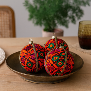 Mahika Bauble – 8cm orange, green, and magenta embroidered ornament with gold trim, handmade in the UK.