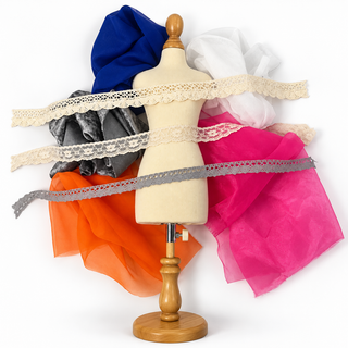 Flat lay of Rainbow Kaleidoscope fabrics in pink, blue, silver, orange and white with lace and crochet trims