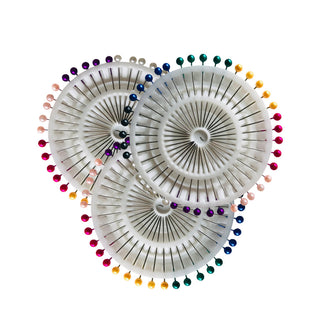 Flat lay of rainbow and white pearl dressmaking pin wheels — compact, colourful, and perfect for sewing, crafting and Mashquin styling.